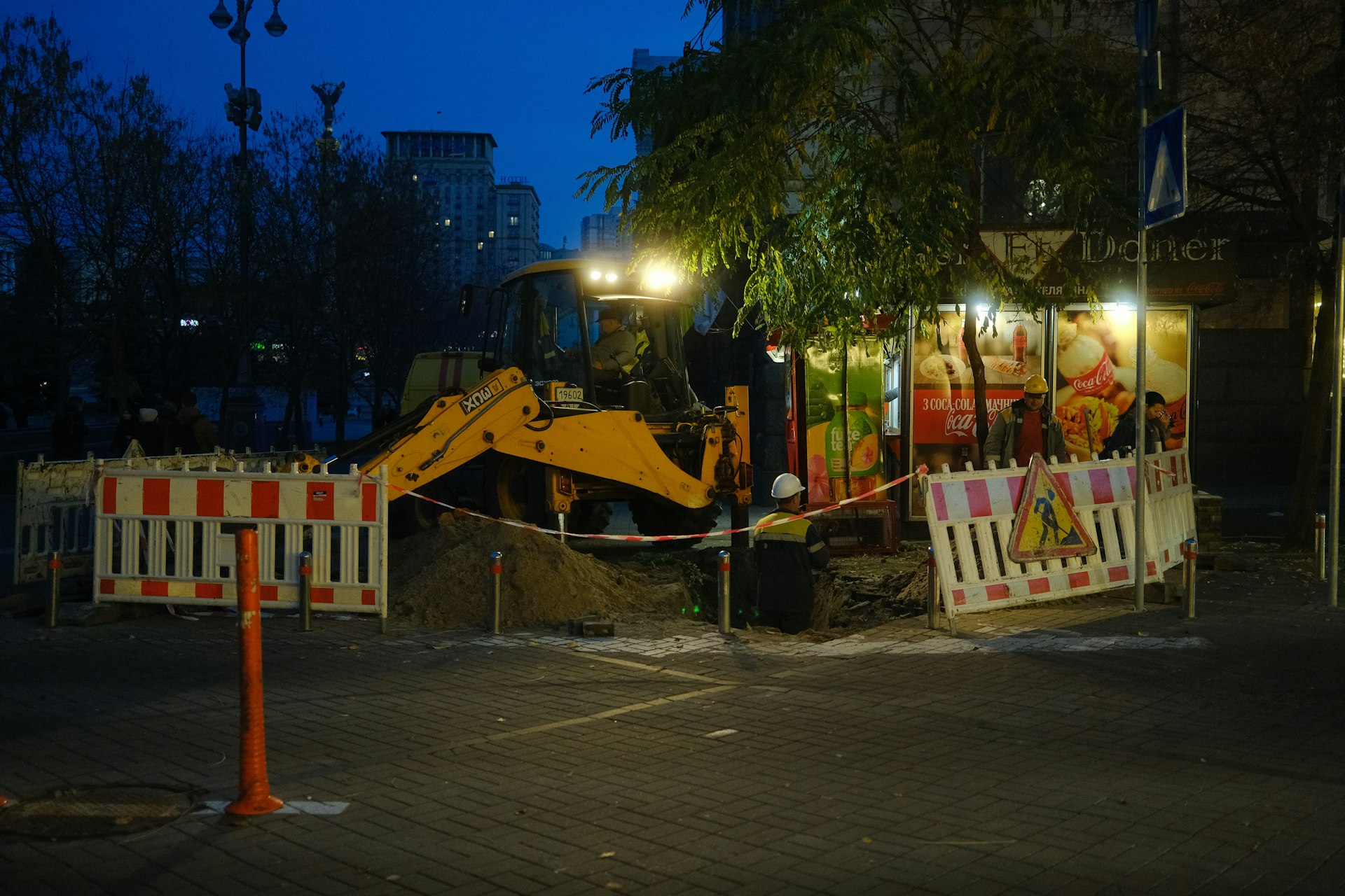 Yellow excavator at a construction site at night.